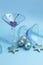 Festive blue martini cocktail glasses with Christmas ornaments - vertical