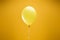 Festive bright minimalistic decorative balloon on yellow background.