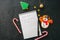 Festive Christmas background, white page of notepad with inscription, candy canes, snowman, stars on a black stone background. To