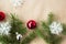 Festive christmas border with red and silver balls on fir branches and snowflakes on rustic beige background