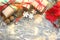 Festive Christmas composition with gifts, boxes, cones, walnuts, red flowers of poinsettia on a wooden background with white sprin