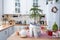 Festive Christmas decor in white kitchen, festive breakfast, white scandi interior. Araucaria as a Christmas tree is decorated and