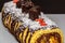 Festive Christmas delicious cake with chocolate. Delicious chocolate rolls with fruits, beautifullly decorated with candy and