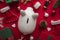 Festive Christmas financial savings concept. White piggy bank money box with presents and decorations