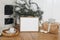 Festive Christmas home decor. Landscape wooden picture frame mockup on parquette floor. Pine, larch tree branches in