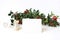 Festive Christmas mockup scene with handmade paper place card, spool of silk ribbon and holly red berries, leaves and