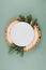 Festive Christmas natural style table setting with white plate on wood cut platters and fir tree branches on green blue background