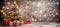 Festive christmas tree with presents against dark gray wall, blurred lights, copy space