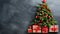 Festive christmas tree with presents against dark gray wall, blurred lights, copy space