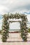 A festive chuppah decorated with fresh beautiful flowers for an outdoor wedding ceremony