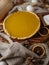 Festive composition - American pumpkin pie, napkin, circles of citrus fruits, cinnamon sticks, cones on a wooden board. Festive