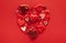 Festive composition with assorted hearts in shape of heart on red background. Top view, copy space. Valentine`s day concept