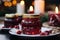 Festive cranberry sauce in glass jars with fresh berries on a candlelit table setting.