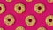 Festive creative pattern of rows of donuts on pink background