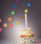 Festive cupcake with candle on grey background with garland