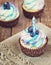 Festive cupcake on a wooden background with bright cream and blueberry with a candle rustic style