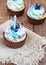 Festive cupcake on a wooden background with bright cream and blueberry with a candle rustic style