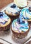 Festive cupcake on a wooden background with bright cream and blueberry with a candle rustic style