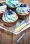 Festive cupcake on a wooden background with bright cream and blueberry with a candle rustic style