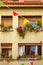 Festive decorated facade of an old European house with flowers and colorful flags