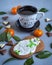 Festive delicious snack with gingerbread and coffee with light ceramic mug, tangerines and chocolate