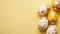 Festive easter background with painted golden decoration on easter eggs on pastel yellow table. Top view and flat lay