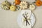 Festive fall autumn Thanksgiving table setting with natural botanical decorations and white fabric tablecloth background