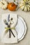 Festive fall autumn Thanksgiving table setting with natural botanical decorations and white fabric tablecloth background