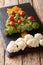 Festive food: a healthy Christmas tree of fresh broccoli, cauliflower, tomatoes, pepper closeup. vertical