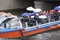 Festive fun event on the water tram with costumed people colorfully dressed and with umbrellas.