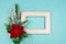 Festive greeting card for Christmas with photo frame, spruce tree branch and poinsettia on blue confetti background