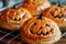 Festive Halloween Pumpkin Shaped Pastries with Spooky Decorations on a Cooling Rack