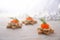 Festive holiday canapes from toasted bread in star shape, cream and red caviar with dill garnish on a light wooden table with