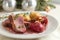 Festive holiday dinner, roasted duck slices with fig, mashed parsnip and red wine sauce on a white plate, Christmas decoration in