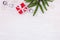 festive holiday white wooden background with green christmas tree branch, glass balls, snowflakes and red handmade gift box with