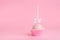 festive icing cake pop over pink background, close up