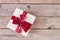 Festive Joy: Red Gift Box with Bow on Retro Wooden Desk