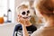 Festive makeup for Halloween. Woman doing skeleton make-up for boy in costume while preparing holiday