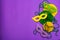 Festive Mardi Gras masquerade purple background. Fat Tuesday carnival, masks, beads, traditional decor