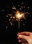 Festive Merry Christmas sparklers. Golden Magic lights for holiday poster, birthday or party concept. Hand, holding Sparkling