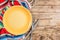 Festive Mexican table setting. Plate and cutlery with colorful napkin on rustic wooden background. Flat lay