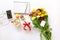 Festive morning concept buttercup flowers bouquet, gift box, cup of cappuccino, makarons cake, mobile, clean notebook, pen on the