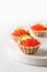 Festive New Year appetizer tartlets stuffed with red caviar and a slice of lime close up on a white tray with copy space