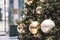 Festive outdoor decorative christmas lights background. Christmas tree branch decorated with baubles, balls on