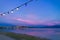 Festive outdoor electric light bulbs under blue sky at dusk