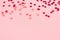 Festive pastel pink background with metallic confetti.