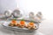 Festive red caviar canapes on toasted bread in star shape with cream and dill garnish on a gray plate, light wooden table with