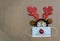 Festive reindeer antlers with face mask and ornaments on brown paper background