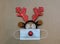 Festive reindeer antlers with face mask and ornaments on brown paper background