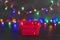 Festive season shopping basket with multicolour Christmas string lights bokeh